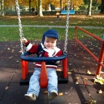 Happiness is swinging in a park on a sunny afternoon in November Happiness is swinging in a park on a sunny afternoon in November