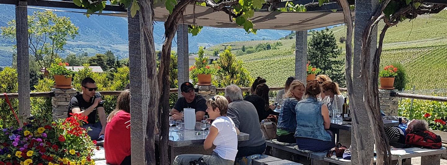 People enjoying Swiss Wine at Caprice Du Temps in Valais, Switzerland